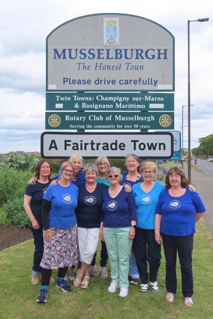 The Honest Singers in front of the Musselburgh Town Sign
